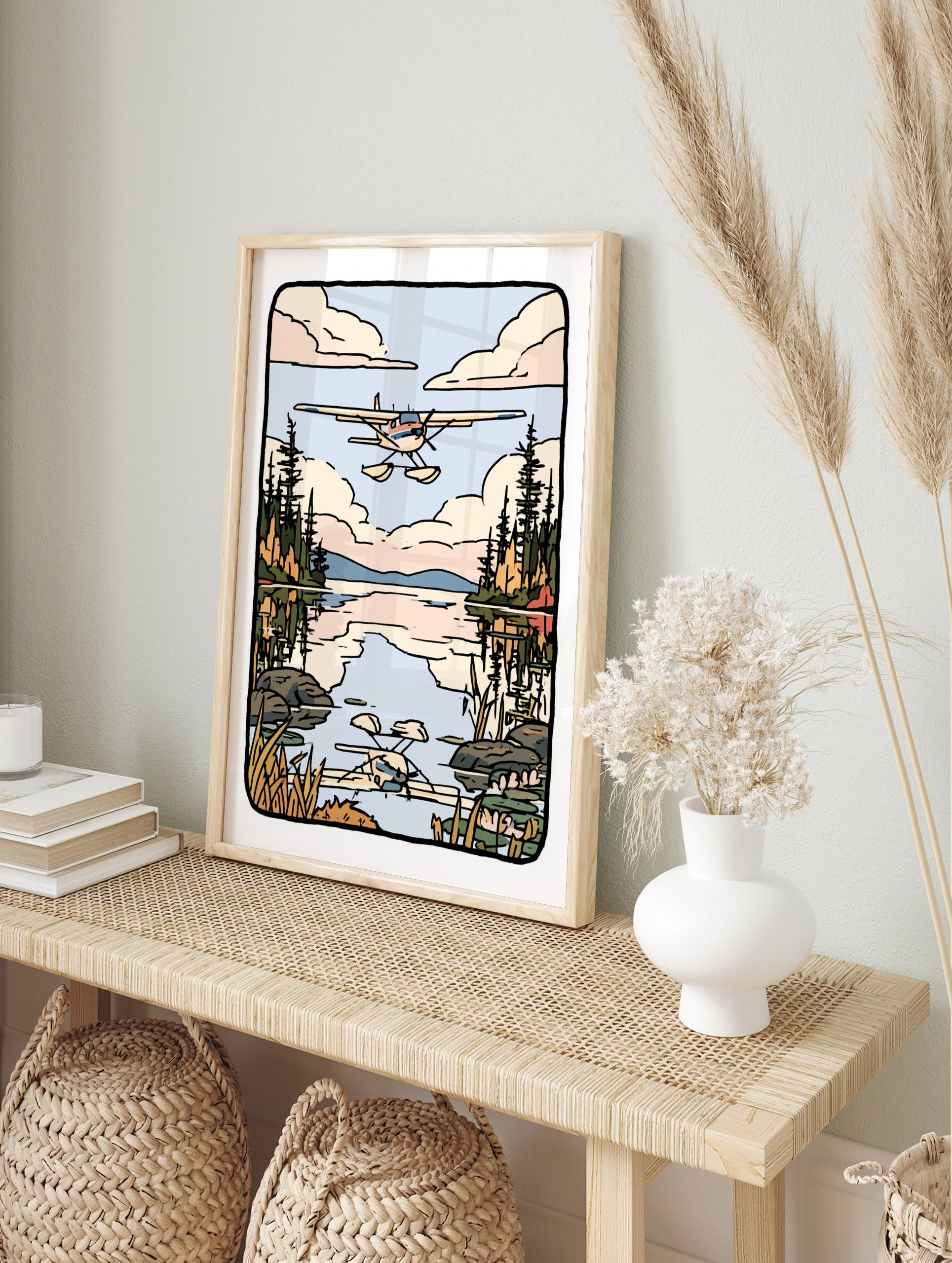 Illustrated seaplane flying over a calm lake with pine forest reflections and soft clouds in, in an alternate framed mockup