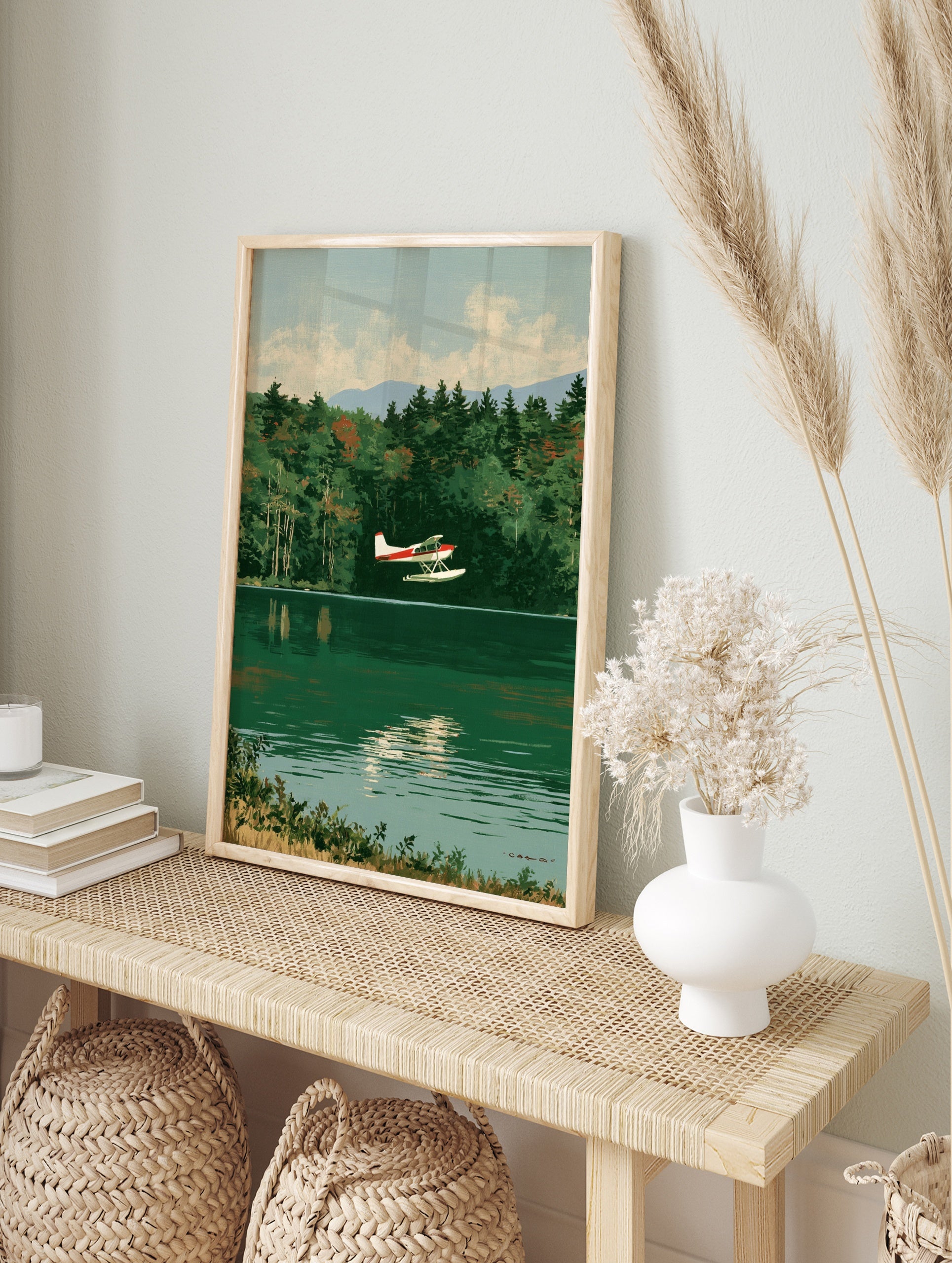 Vintage style illustration of a red and white seaplane flying over a calm green lake with a, in an alternate framed mockup