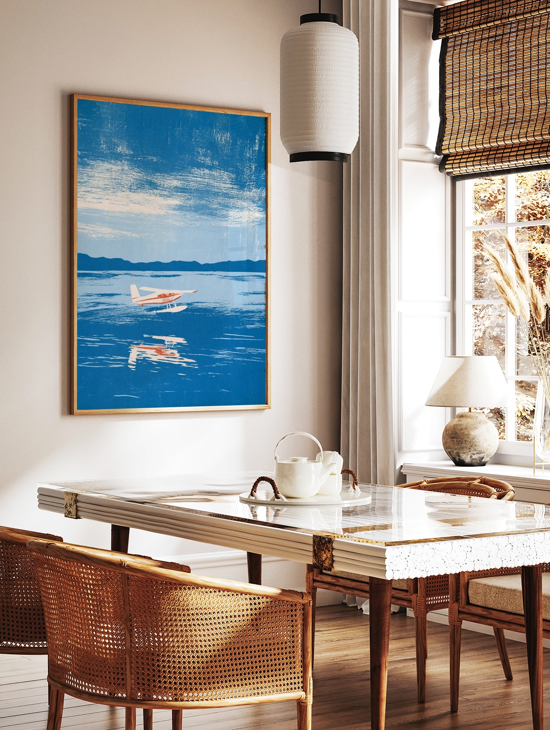 Illustrative seaplane wall art print flying over blue water with mountain background, in a styled room mockup