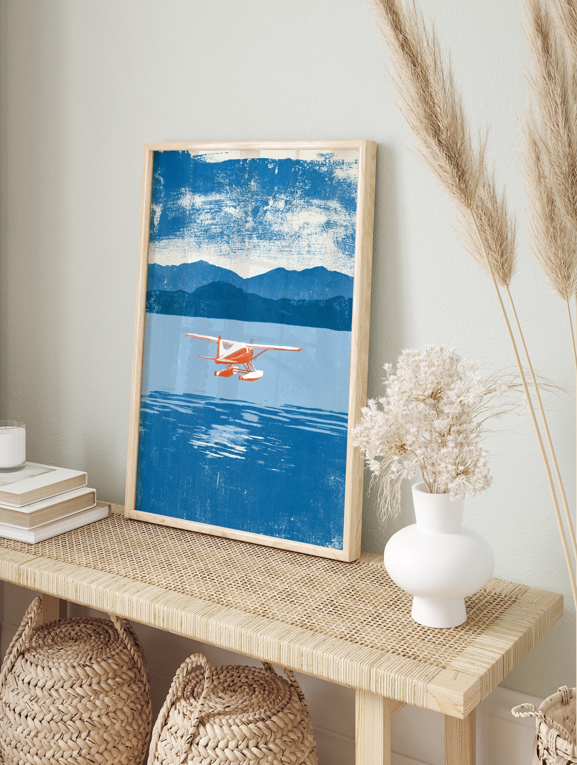 Red and white seaplane flying over blue water with mountains in the background, illustrative, in an alternate framed mockup