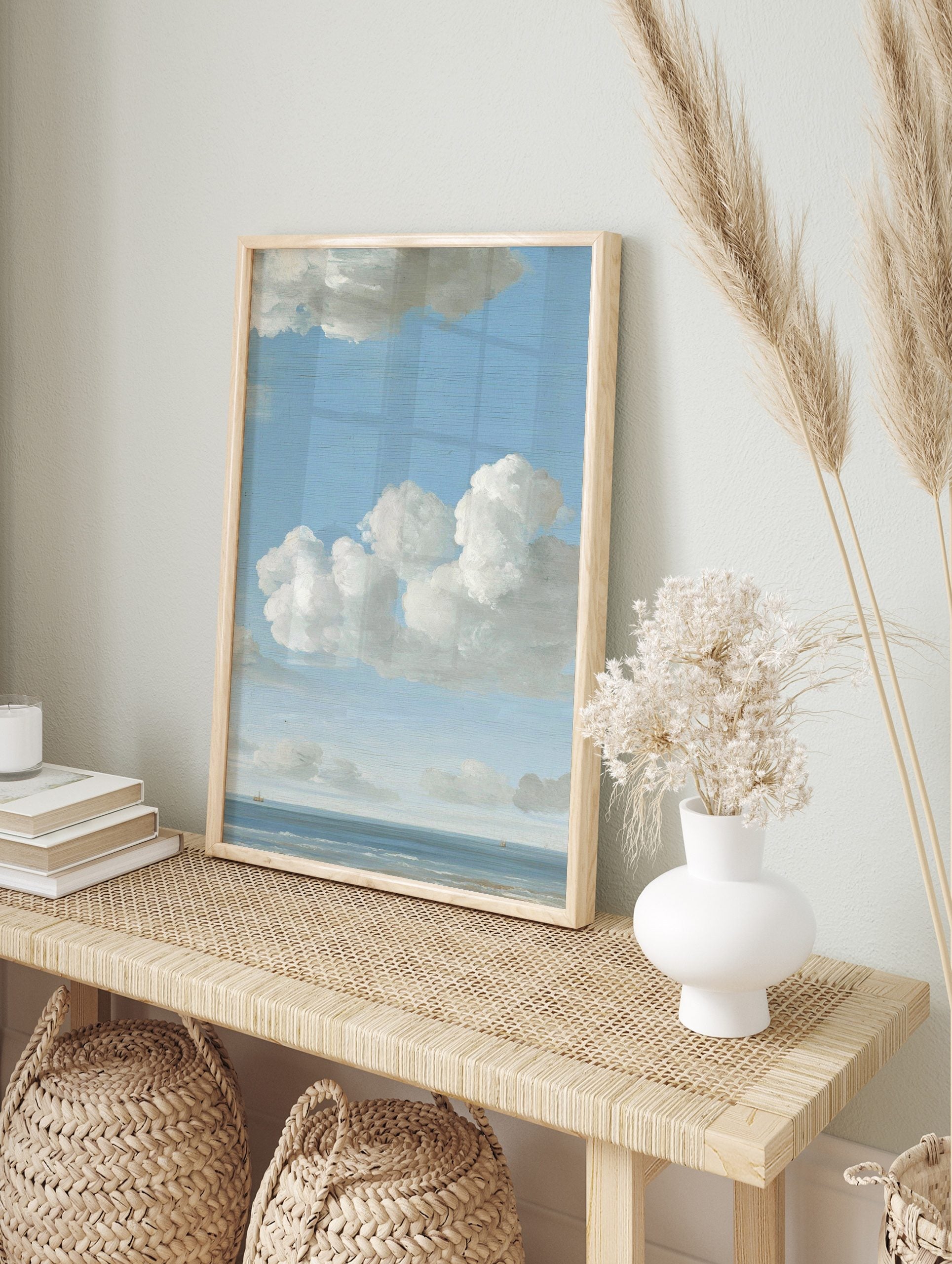 Seascape painting with blue sky, white cumulus clouds, calm ocean, and two small distant, in an alternate framed mockup
