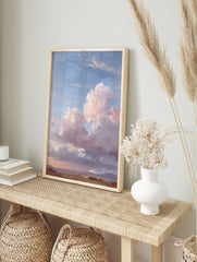 Painterly landscape wall art with vast blue sky, large pink and grey clouds, and earthy, in an alternate framed mockup
