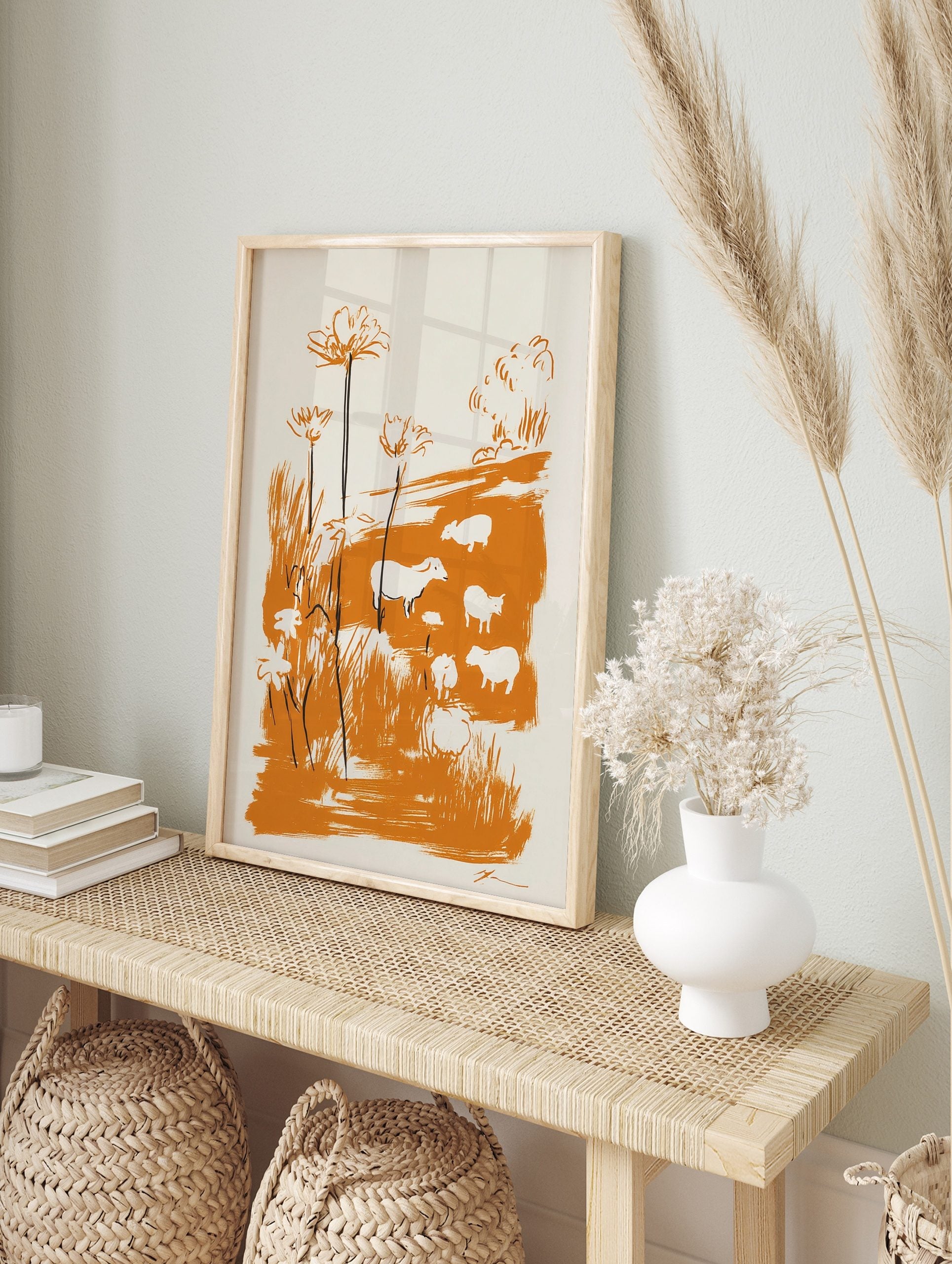 Illustrative print of white sheep and tall flowers in an orange meadow with bold brushstrokes, in an alternate framed mockup