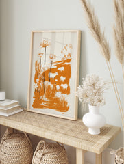 Illustrative print of white sheep and tall flowers in an orange meadow with bold brushstrokes, in an alternate framed mockup