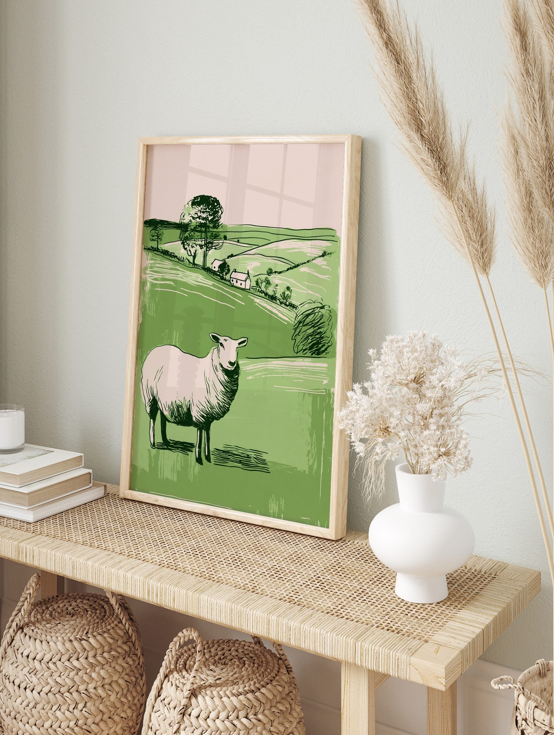 Illustrative white sheep in green pastoral landscape with hills, trees, and two cottages, in an alternate framed mockup