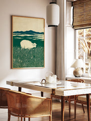 Art print of a white sheep grazing in a lush green field with distant blue mountains under a cream sky, in a woodcut style. - Image 2