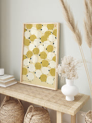 Repeating pattern of mustard yellow and white sheep with black faces on a cream background, in an alternate framed mockup