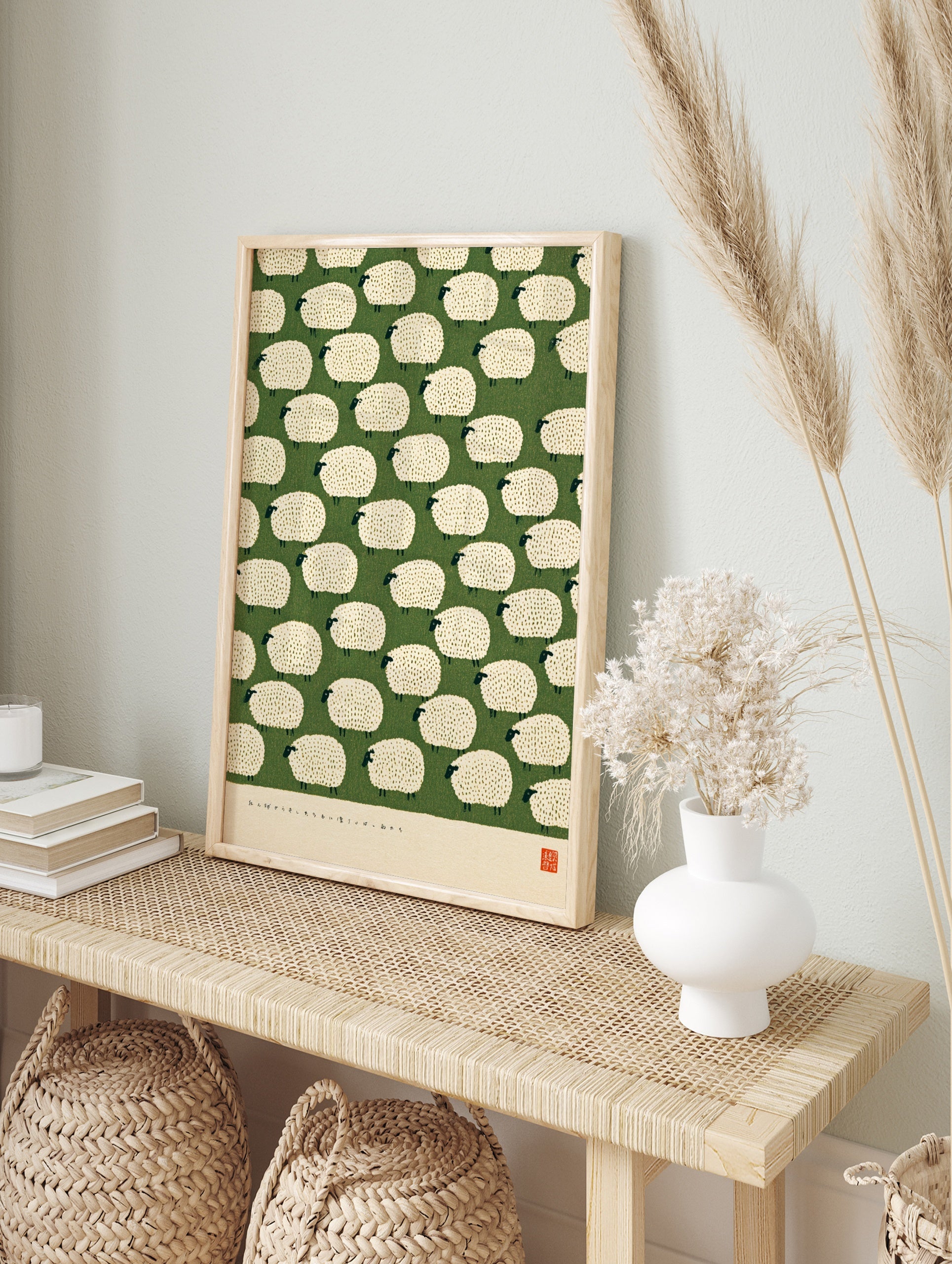 Illustrative pattern of white fluffy sheep on a green background with a red artist seal at, in an alternate framed mockup