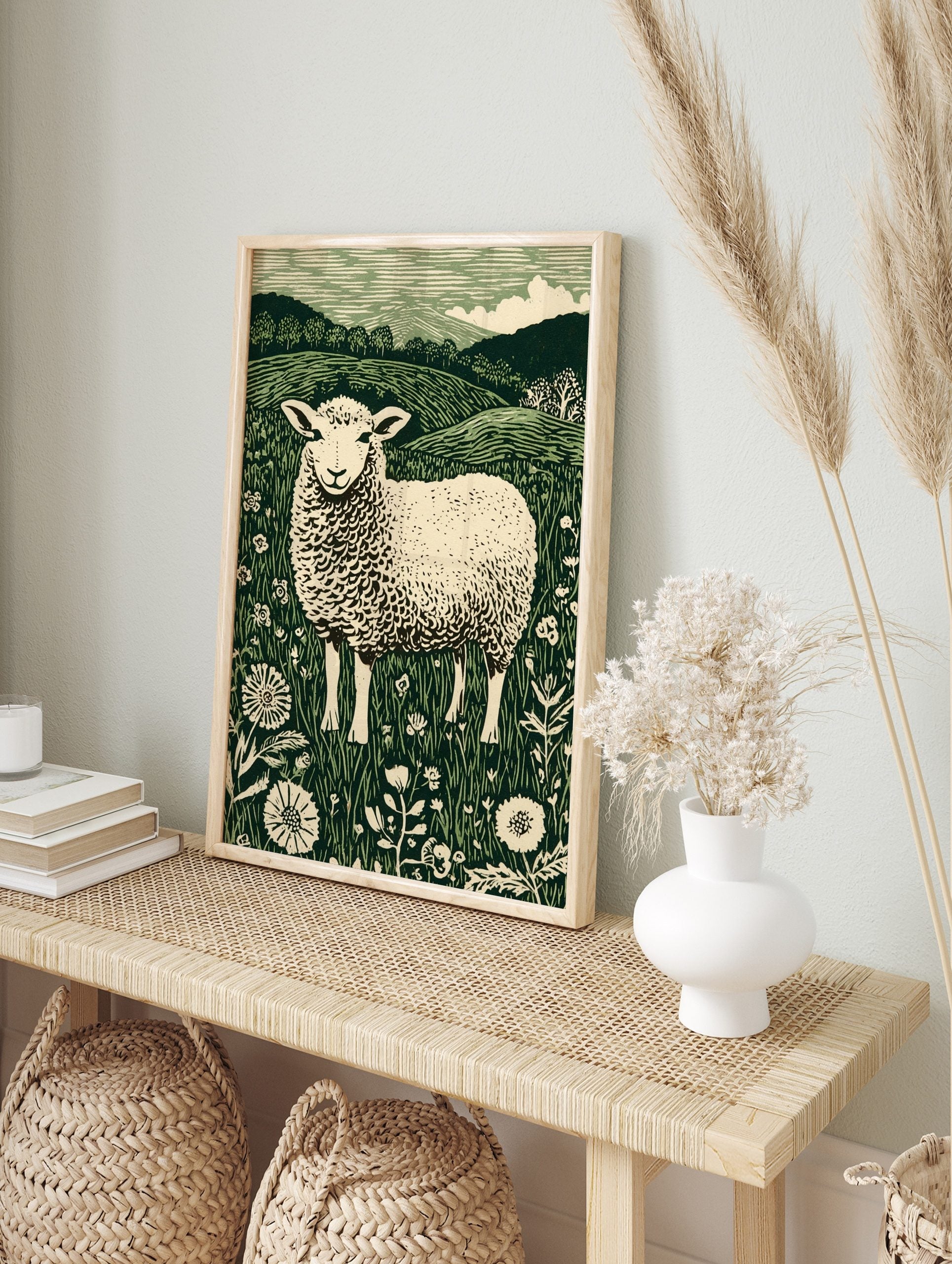 Illustrative green and white sheep in a field of flowers with hills and trees in background, in an alternate framed mockup