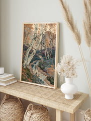 Watercolour painting of silver birch trees and a winding stream in an autumn forest landscape, in an alternate framed mockup