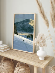 Illustrative art print of a lone skier on a vast snow-covered mountain landscape with blue, in an alternate framed mockup