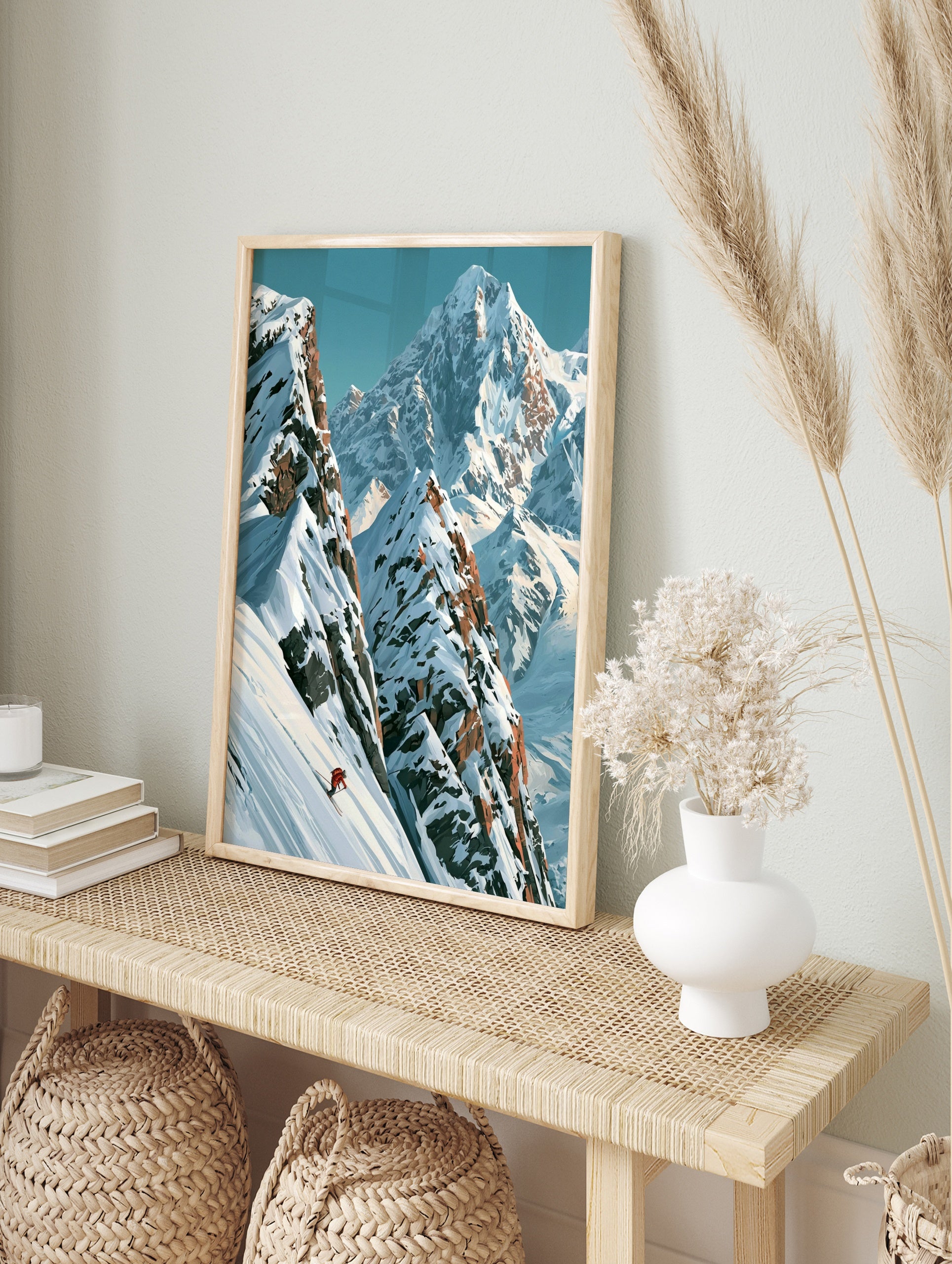 Illustrative mountain wall art print featuring a lone skier in a red jacket on a steep snowy, in an alternate framed mockup