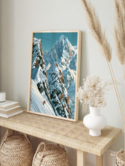 Illustrative mountain wall art print featuring a lone skier in a red jacket on a steep snowy, in an alternate framed mockup
