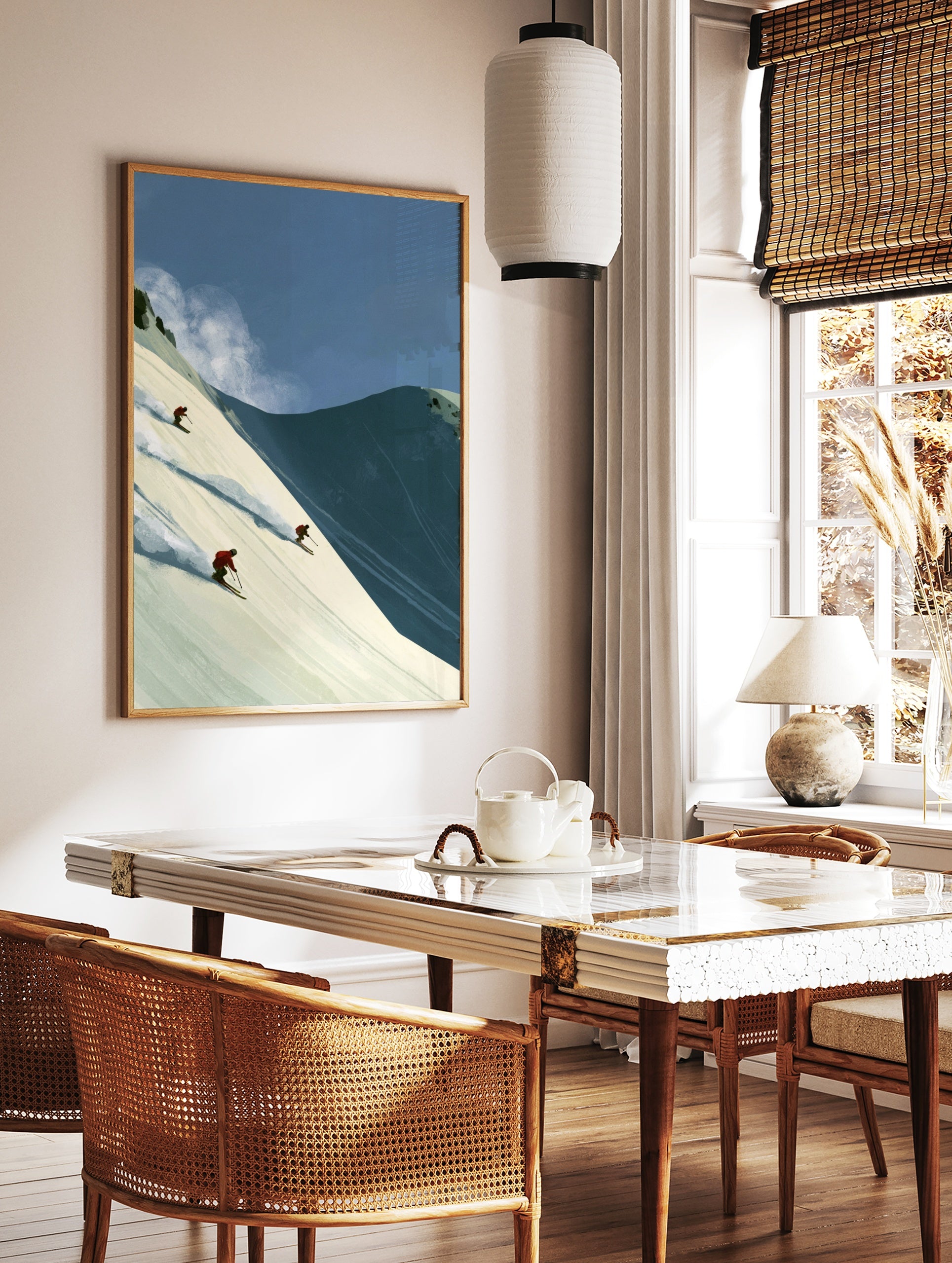 Illustrative wall art of three skiers in red jackets descending a steep snowy mountain slope with, in a styled room mockup