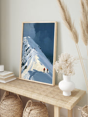 Illustrative mountain landscape art print featuring skiers in orange jackets on a snowy ridge, in an alternate framed mockup
