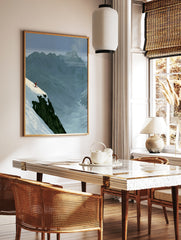 Minimalist illustration of a skier on a snowy mountain cliff edge, blue mountain background, red, in a styled room mockup