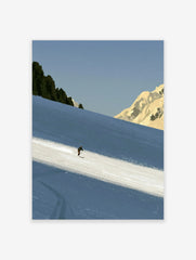 Minimalist skiing mountain wall art featuring a lone skier on a blue snowy slope with rocky peaks