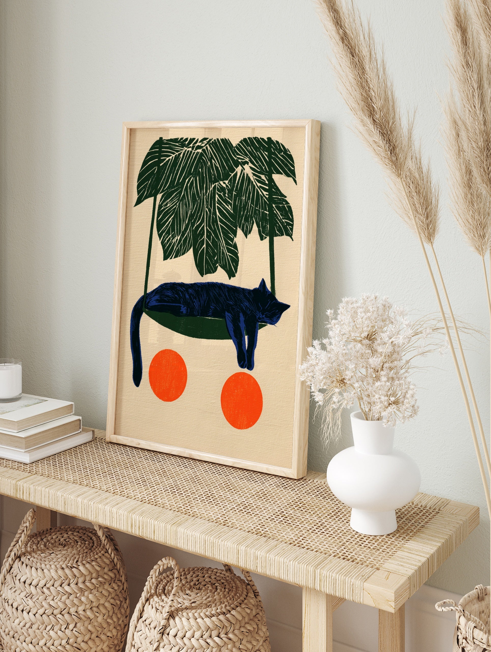 Illustrative blue cat sleeping in a green hammock under palm leaves with two orange circles, in an alternate framed mockup
