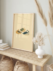 Illustrative print of three sleeping ducks in golden-brown, dark blue, and floral green on a, in an alternate framed mockup