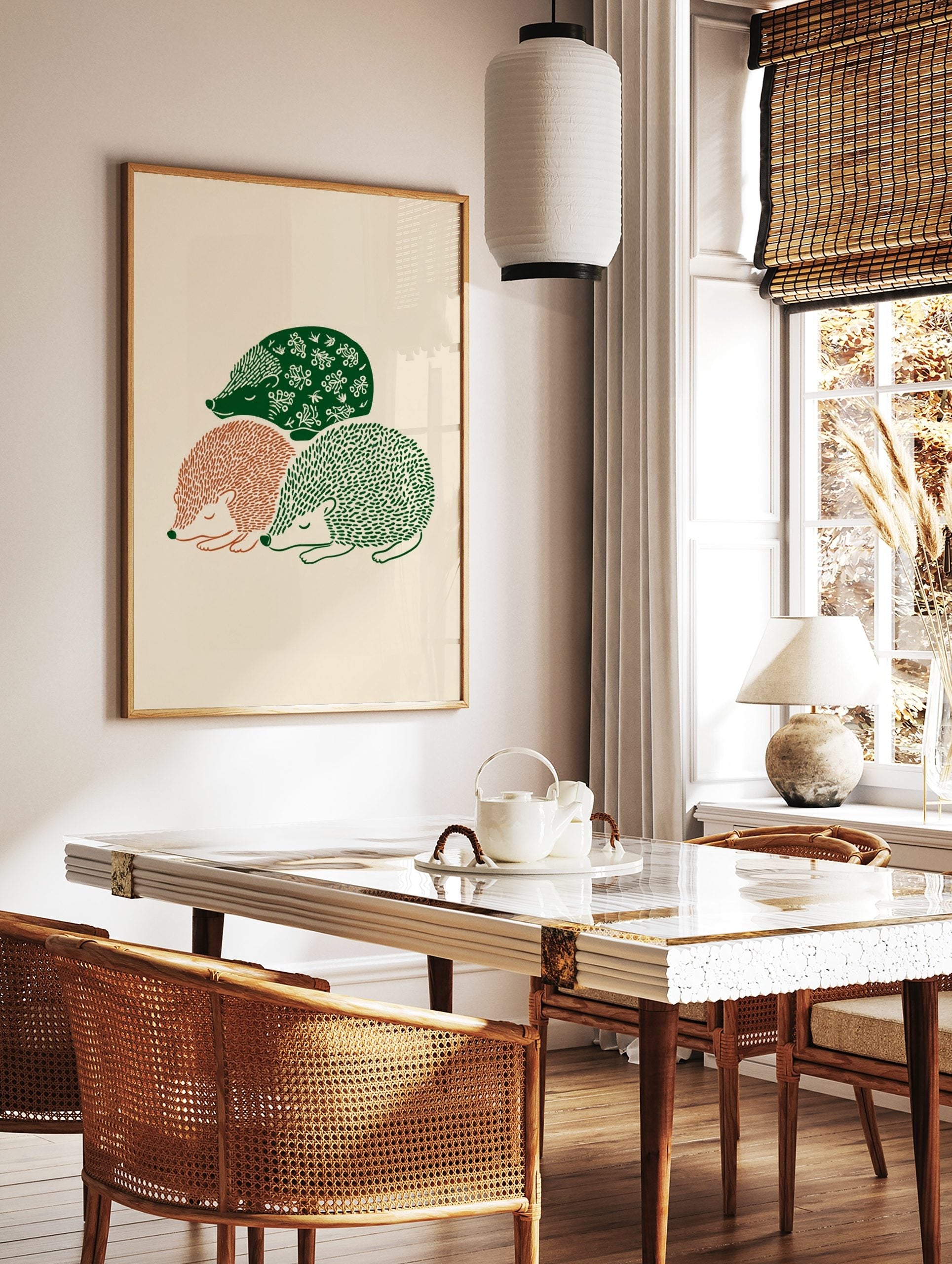 Three sleeping hedgehogs in green and terracotta folk art illustration on a beige background, in a styled room mockup