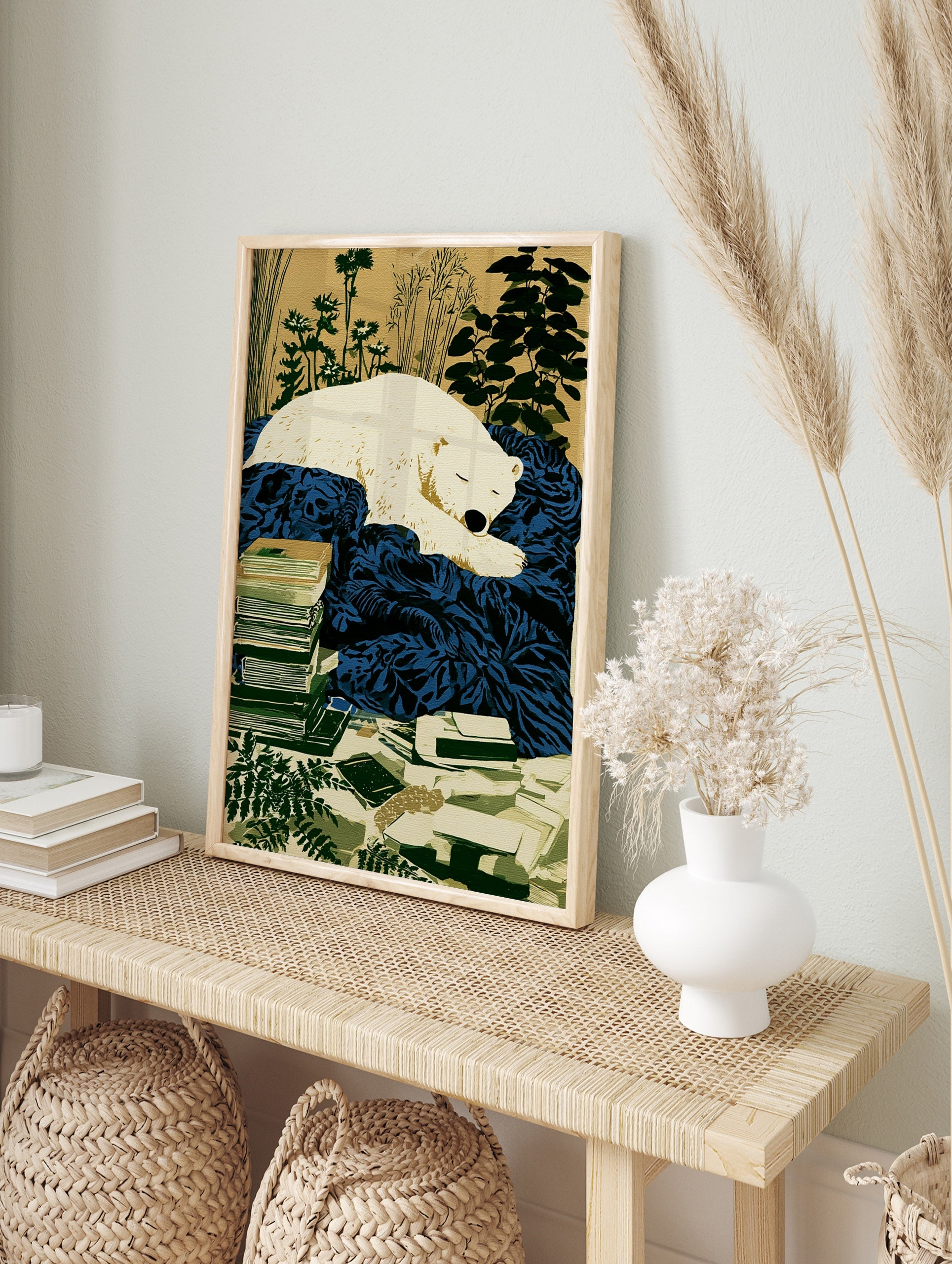 Illustration of a sleeping white polar bear on a deep blue blanket, with stacked books and, in an alternate framed mockup