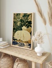 Sleeping polar bear illustration on cream background with green and blue patterned details, in an alternate framed mockup