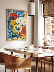 Illustrative art print of a sleeping polar bear on a yellow armchair with blue botanical plants and, in a styled room mockup