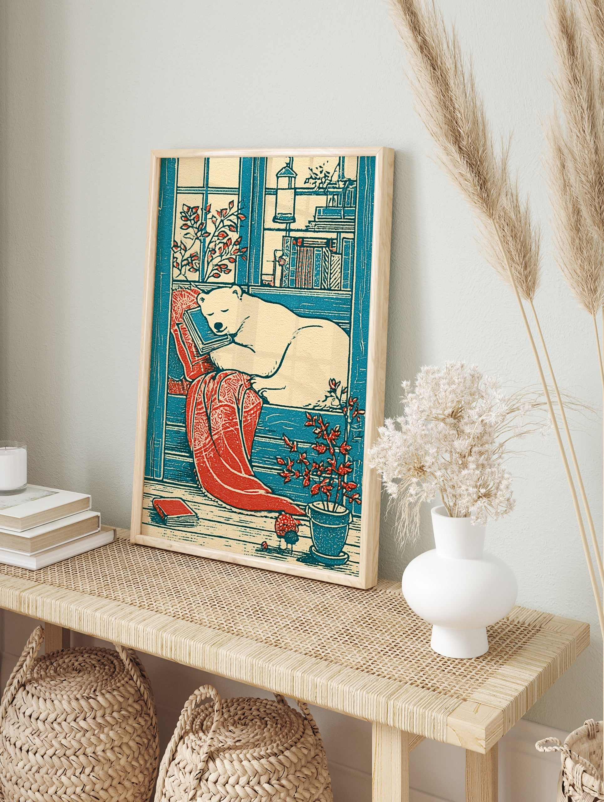 Illustrative polar bear sleeping on a stack of books with a red blanket and potted plant in, in an alternate framed mockup