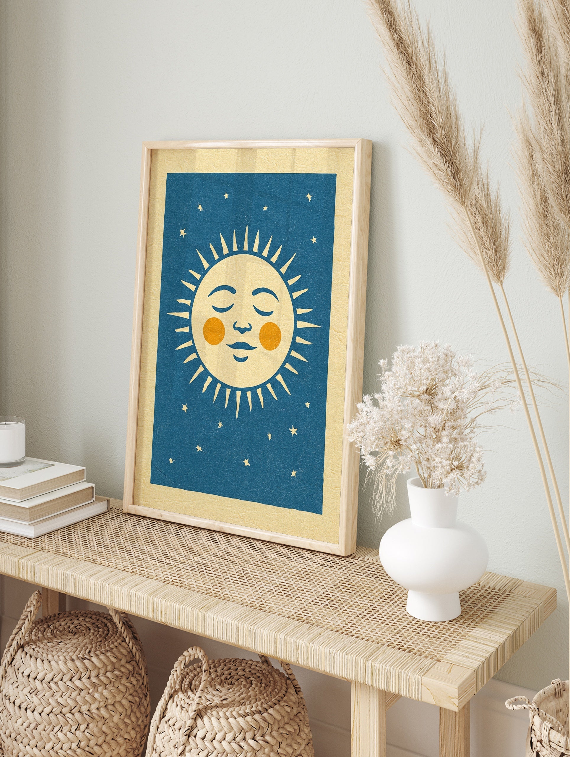 Retro sleeping sun illustration with orange cheeks and stars on a deep blue background, in an alternate framed mockup