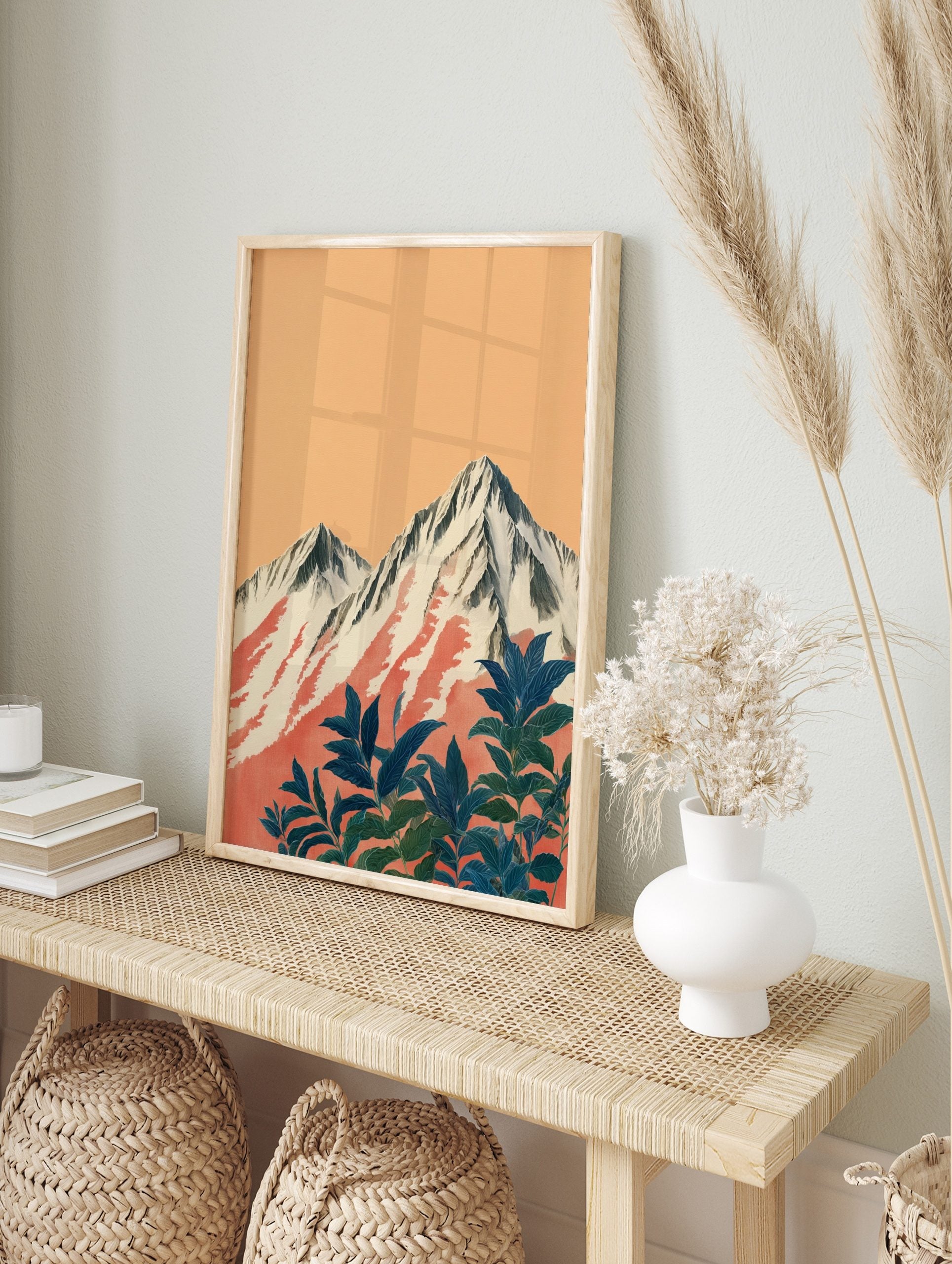 Illustrative print of snow-capped mountains with red streaks and dark blue-green foliage, in an alternate framed mockup