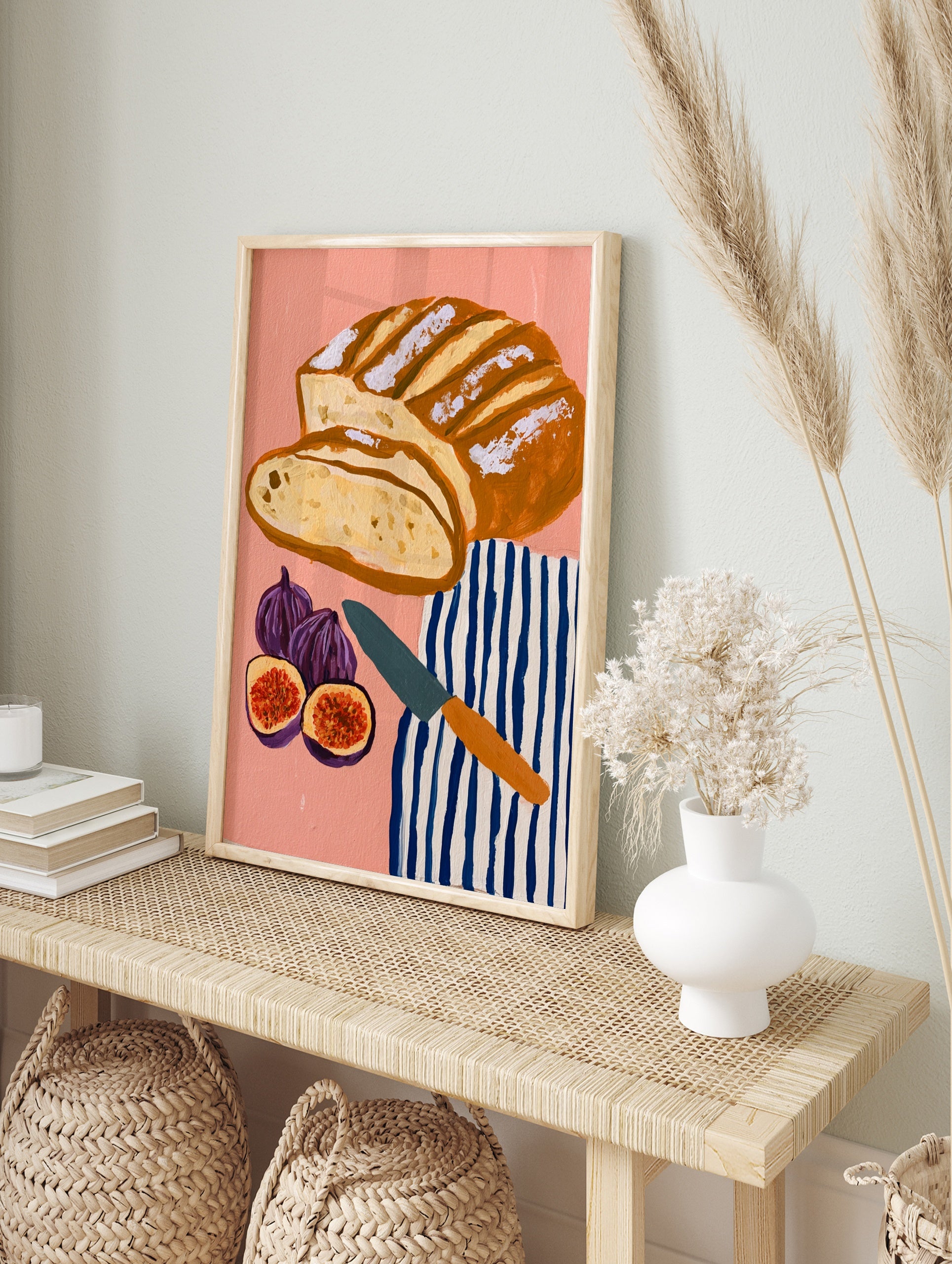 Illustrative art print of sliced sourdough bread, figs, and a striped tea towel on a pink, in an alternate framed mockup