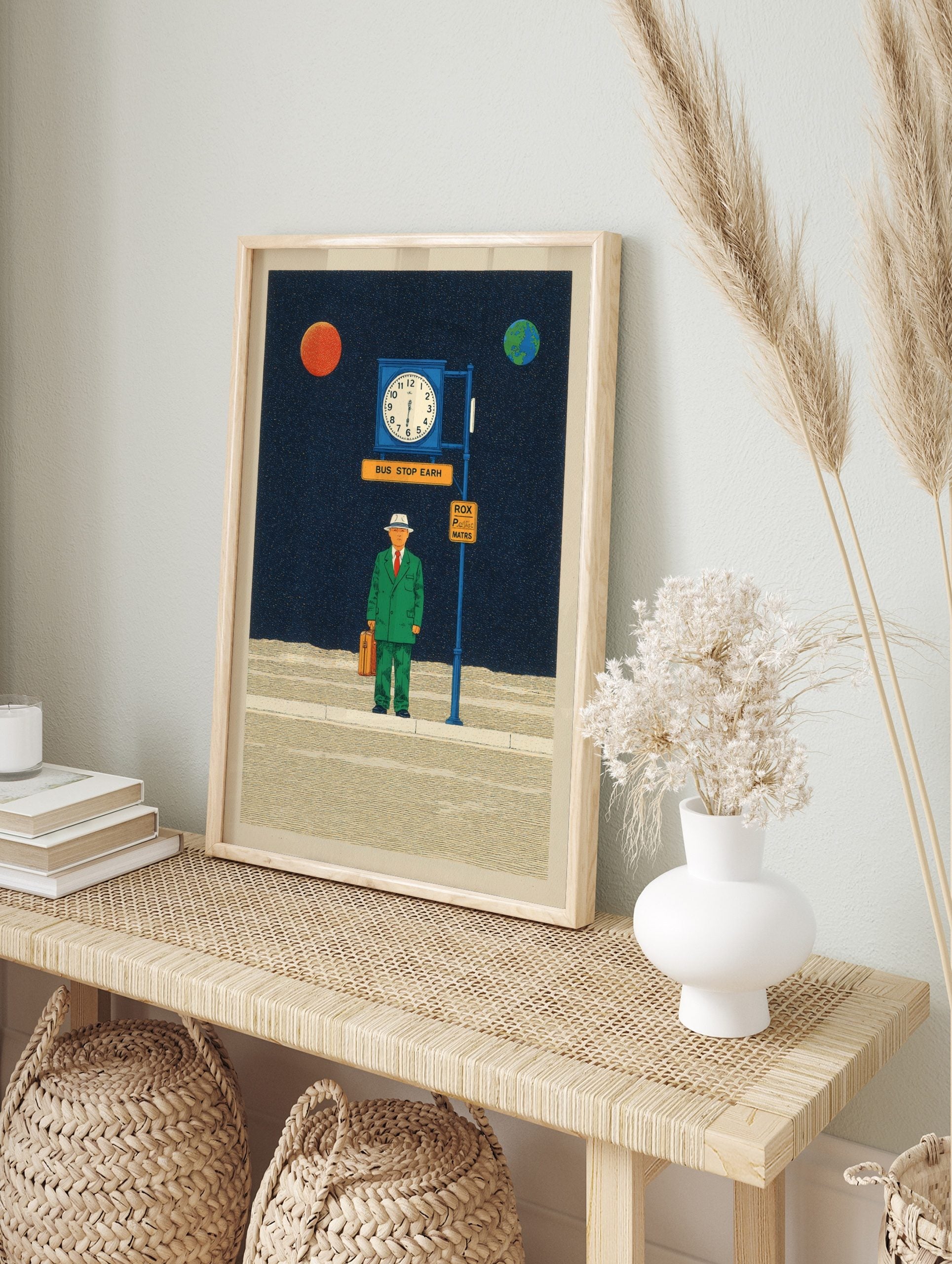 Surreal illustrative print of a man in green suit at a bus stop in space with planets and, in an alternate framed mockup