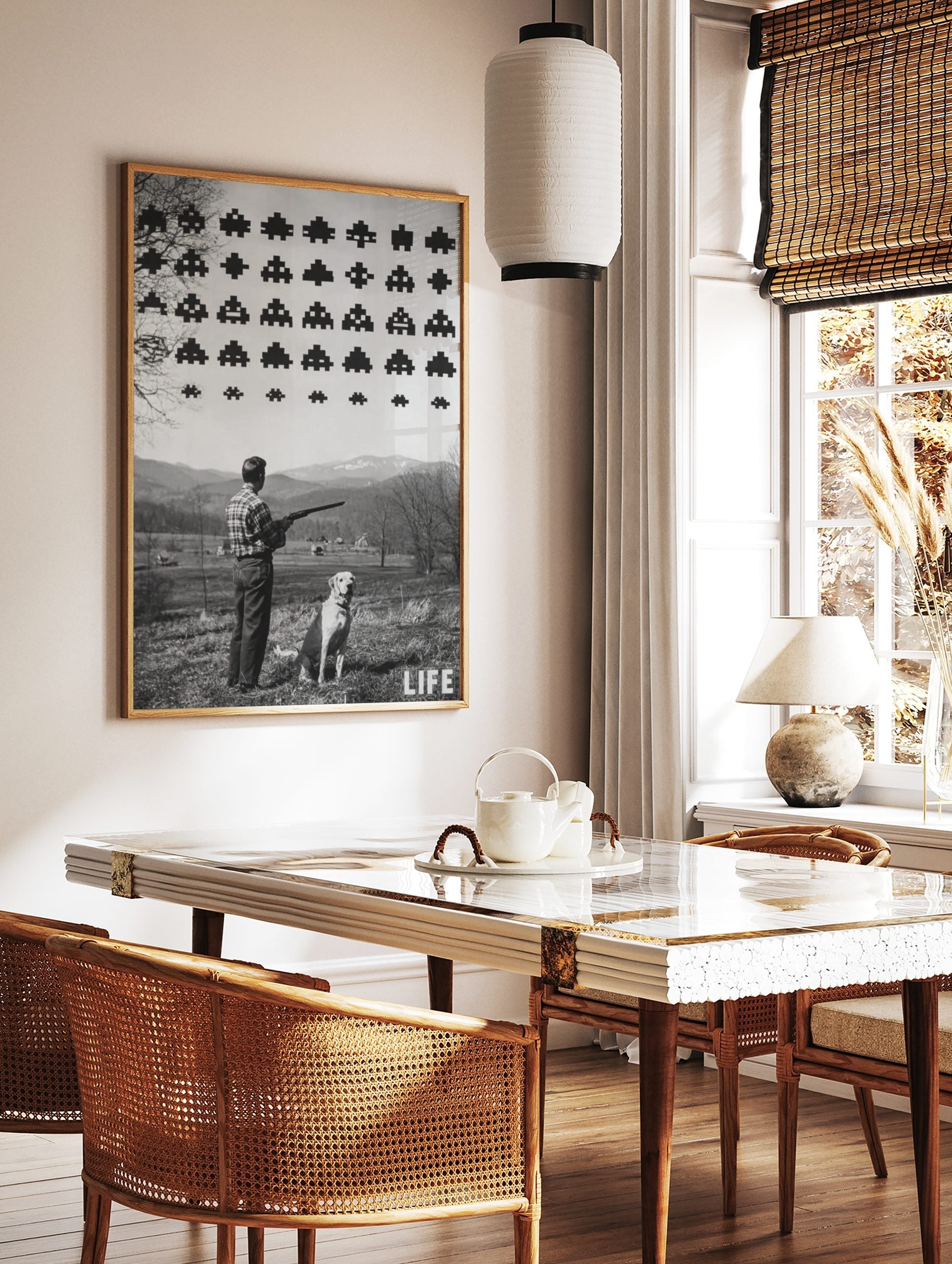 Monochrome print of a man with a shotgun and dog looking at pixelated Space Invaders in a rural, in a styled room mockup