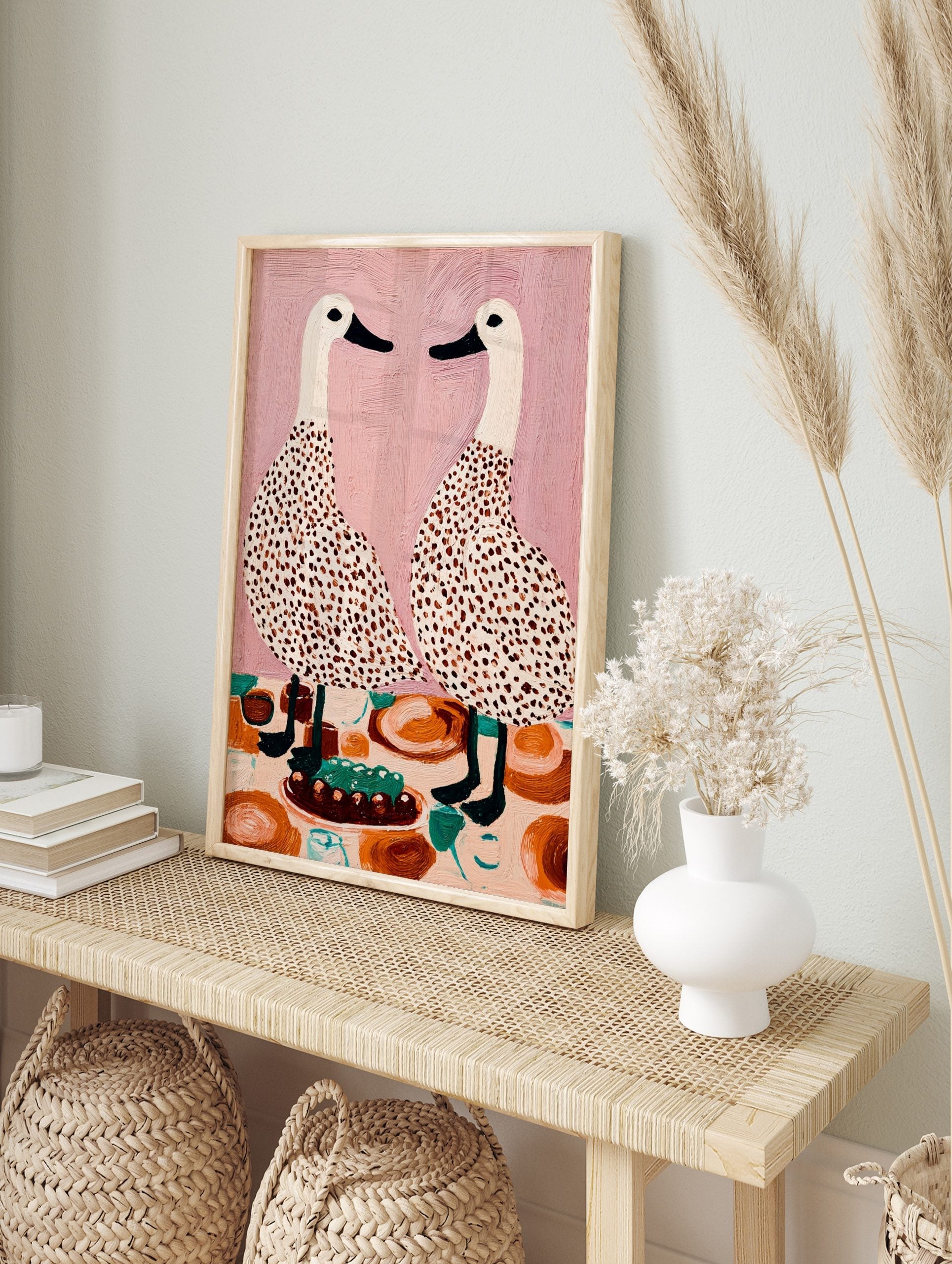 Illustrative wall art of two speckled white ducks facing each other at a dining table with a, in an alternate framed mockup