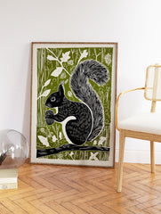 Black squirrel linocut art print on a green background, holding an acorn while sitting on a branch, woodland animal decor. - Image 2