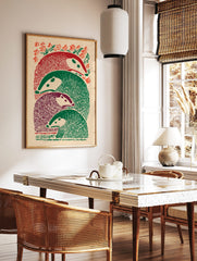Illustrative print of four stacked badger-like animals in red, green, and purple, with foliage, in a styled room mockup