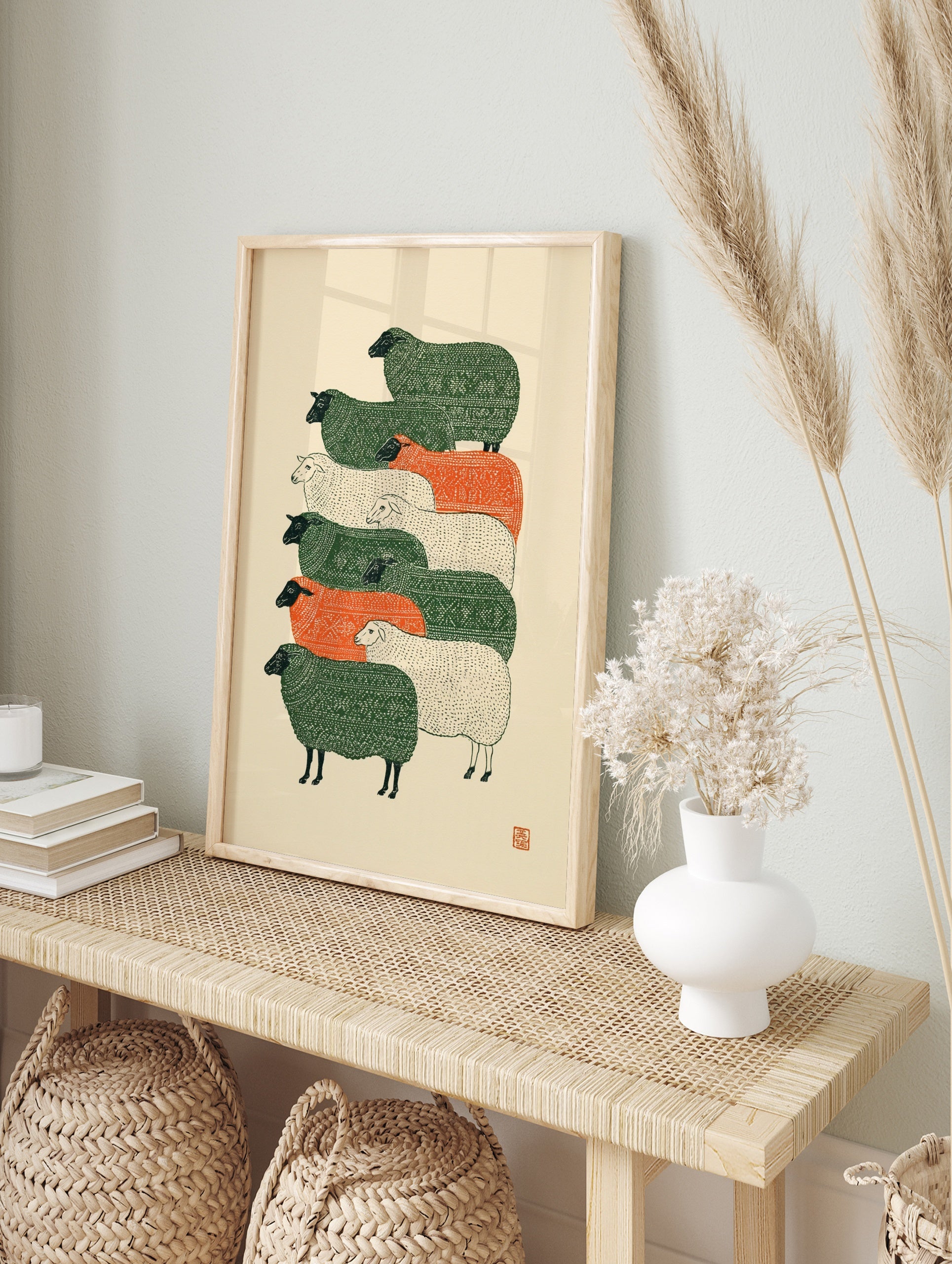 Stylised stacked sheep illustration with green, orange, and cream textured patterns on a, in an alternate framed mockup