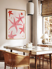 Pink starfish illustration art print with small stars on a neutral background, in a styled room mockup