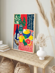 Still life fruit poster with lemons, grapefruit, limes, blue bottle, and vase with green leaves on a patterned red and blue tablecloth. - Image 4