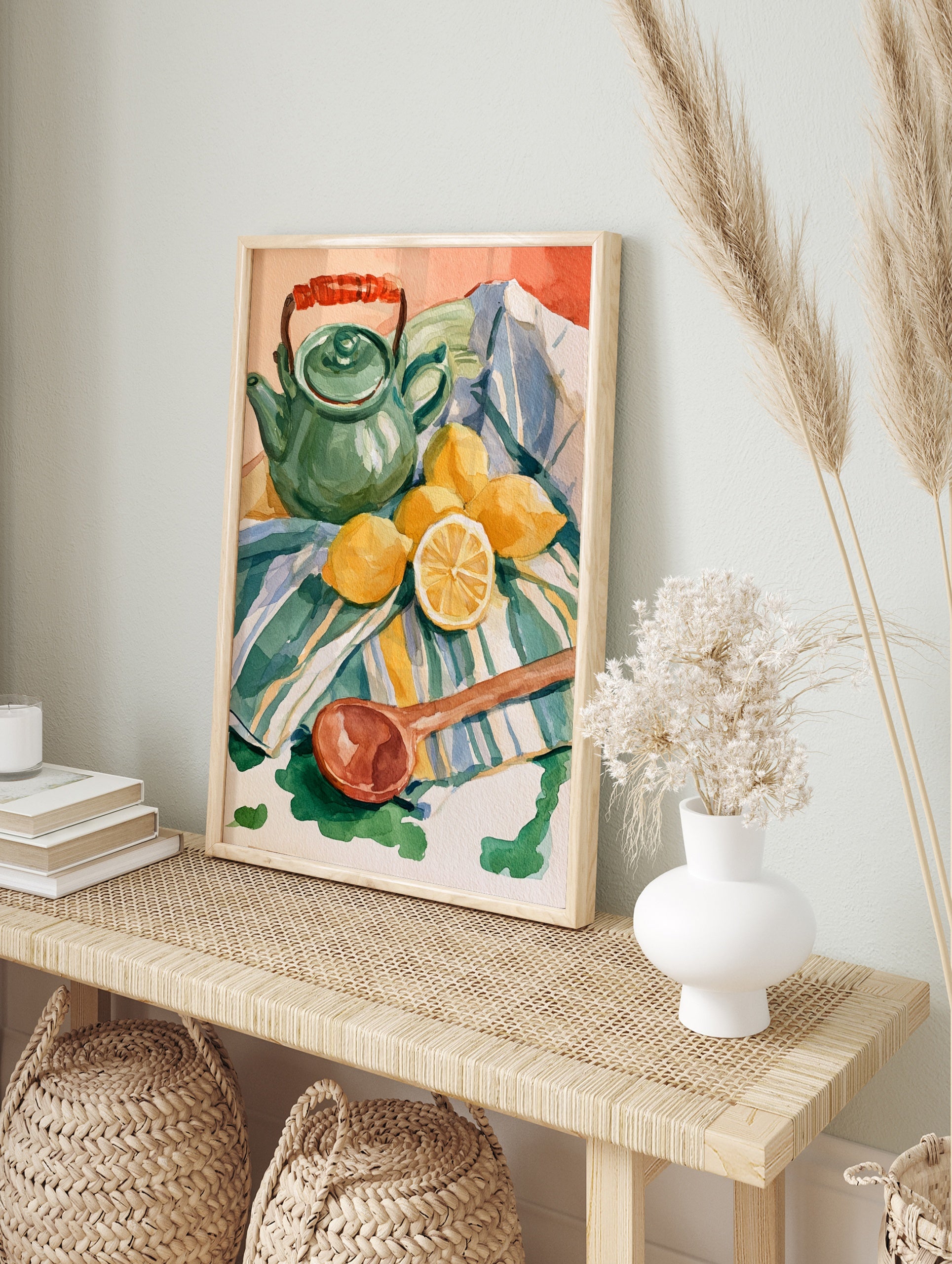 Watercolor still life illustration of a green teapot, lemons, and a wooden spoon on a striped, in an alternate framed mockup
