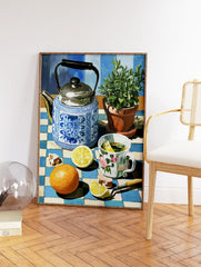 Still life painting of a blue and white teapot, lemon tea, orange, and plant on a checkered tablecloth, vibrant kitchen wall art. - Image 2