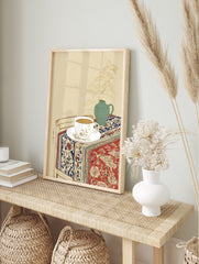 Still life wall art illustration of a tea cup, green vase with plant, and patterned red and blue textile on a table. - Image 3
