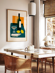 Modern still life wall art with wine bottle, cocktail glass, and lemons on a teal table against an, in a styled room mockup