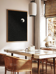 Stippled eyeball art print with a black pupil and light sclera on a speckled black background, in a styled room mockup