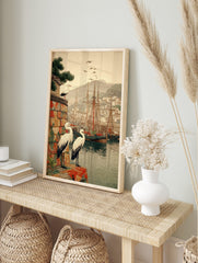Japanese woodblock style print of white storks overlooking a harbour with ships and a, in an alternate framed mockup