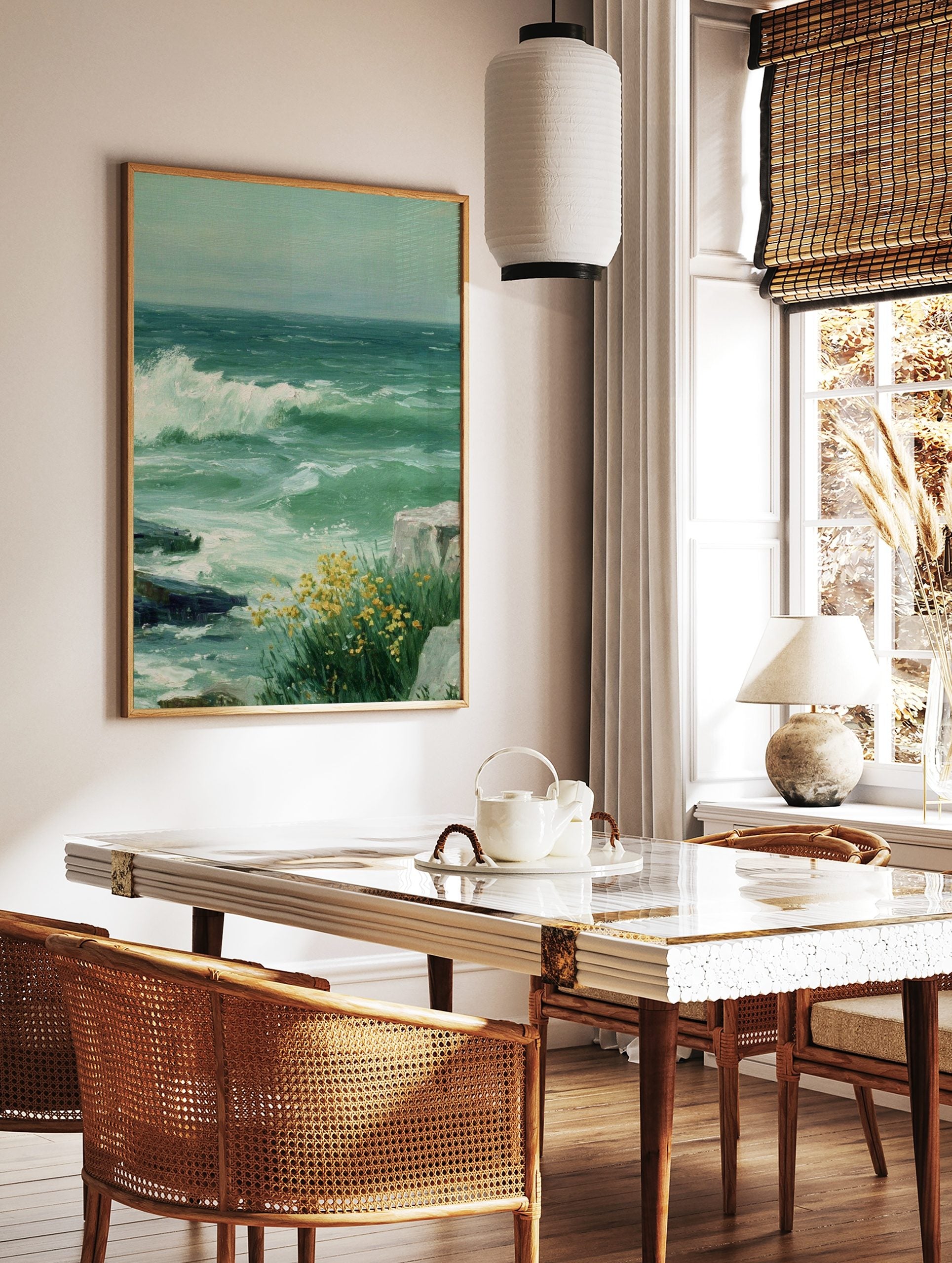 Painting of stormy green sea with a large white wave crashing on rocks and yellow flowers, in a styled room mockup