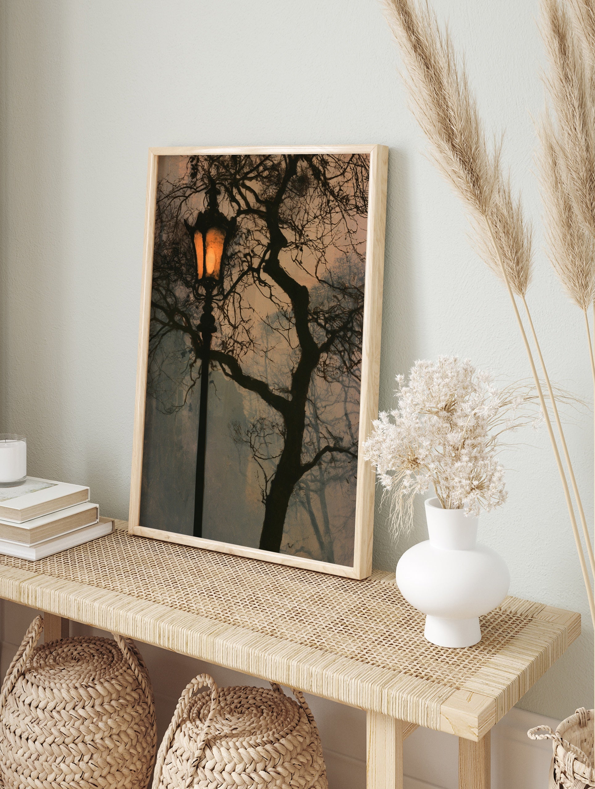 Street lamp at night with glowing light and dark tree branches against a muted sky, in an alternate framed mockup