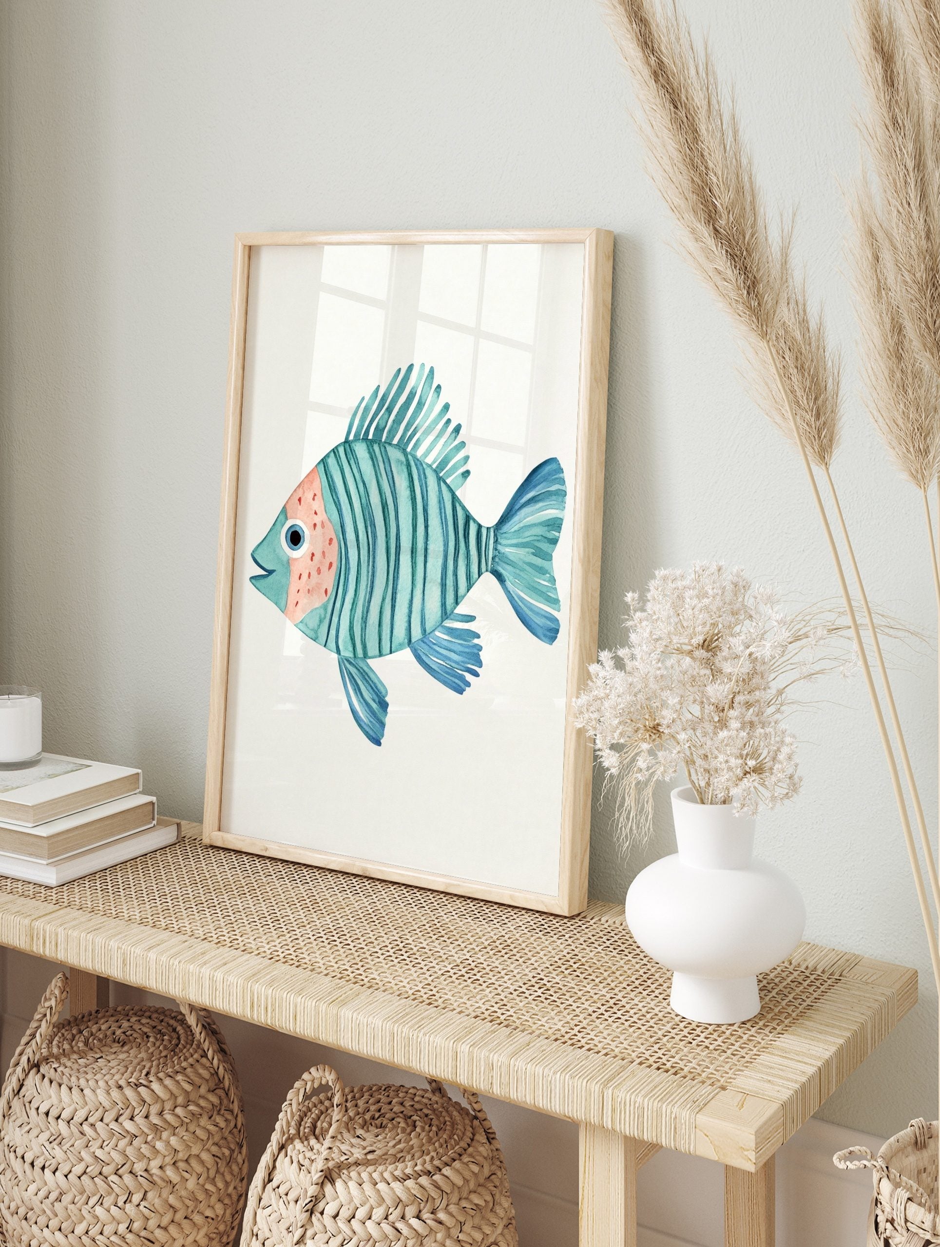 Watercolour illustration of a teal striped fish with peach face and blue fins on a white, in an alternate framed mockup