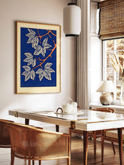 Stylised botanical leaf illustration art print with white leaves, orange branches, and a deep blue, in a styled room mockup