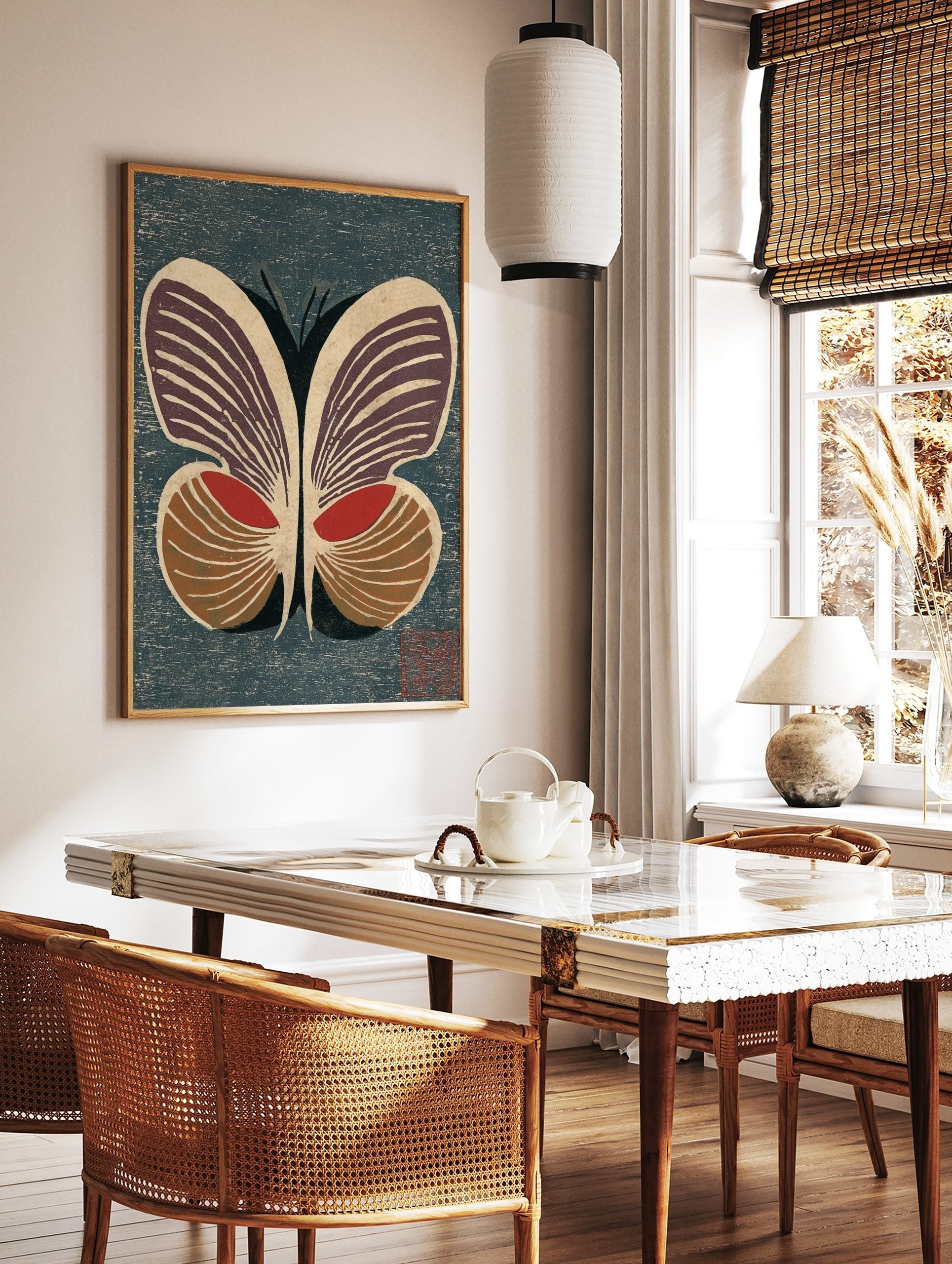 Stylised butterfly woodblock print with deep purple, red, and brown wings on a textured dark blue, in a styled room mockup